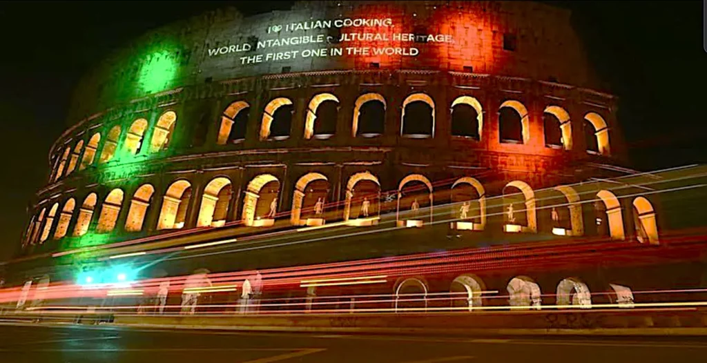 Coliseo iluminado festejando la declaración UNESCO cocina italiana patrimonio de la humanidad
